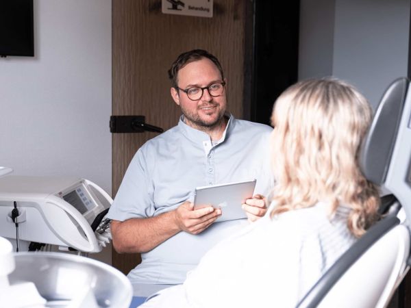 Zahnarzt Steffen Hüning bei der Beratung einer Patientin in der Zahnarztpraxis Dr. Hüning – Zahnärzte Bochum-Harpen