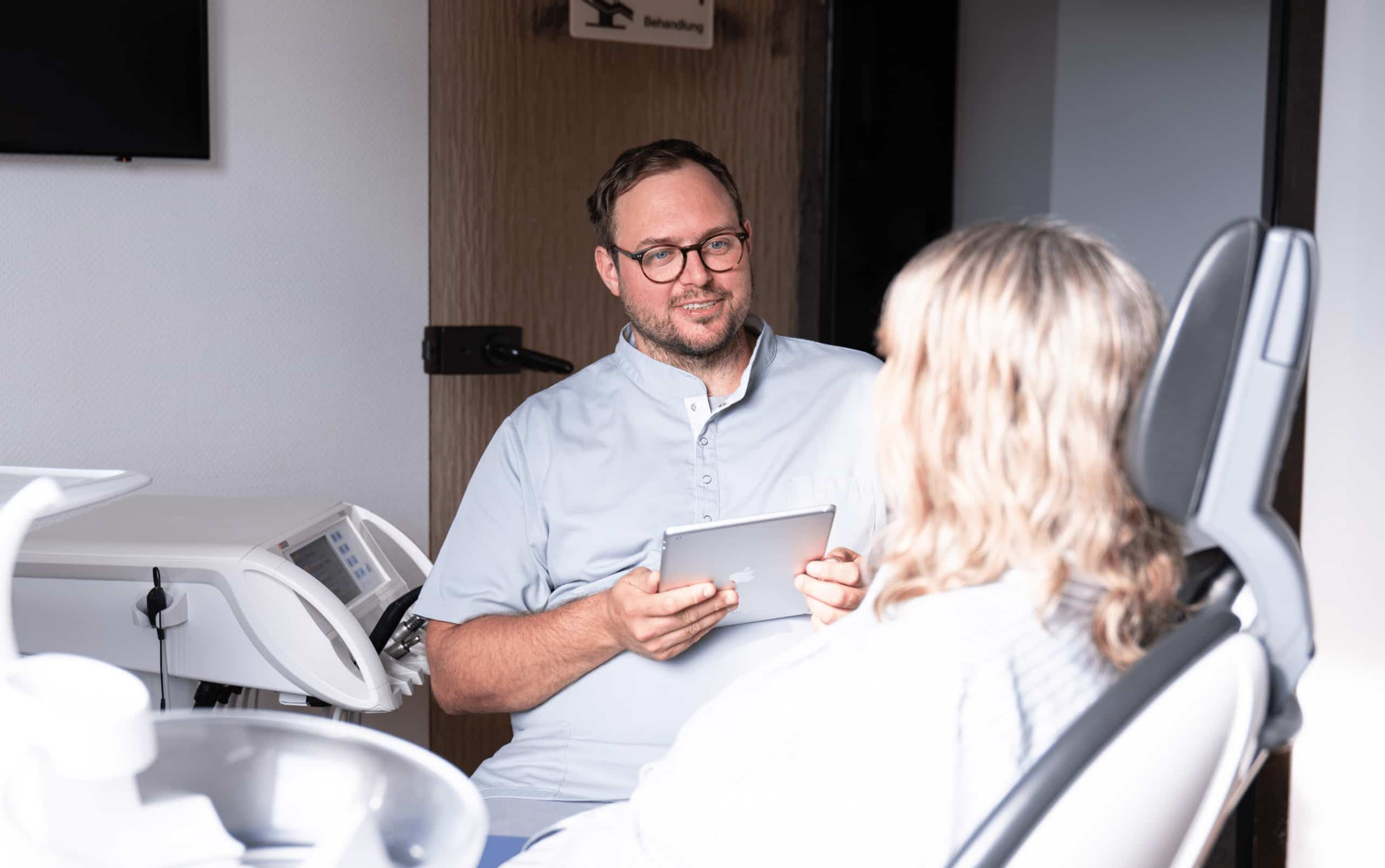 Zahnarzt Steffen Hüning bei der Beratung einer Patientin in der Zahnarztpraxis Dr. Hüning – Zahnärzte Bochum-Harpen