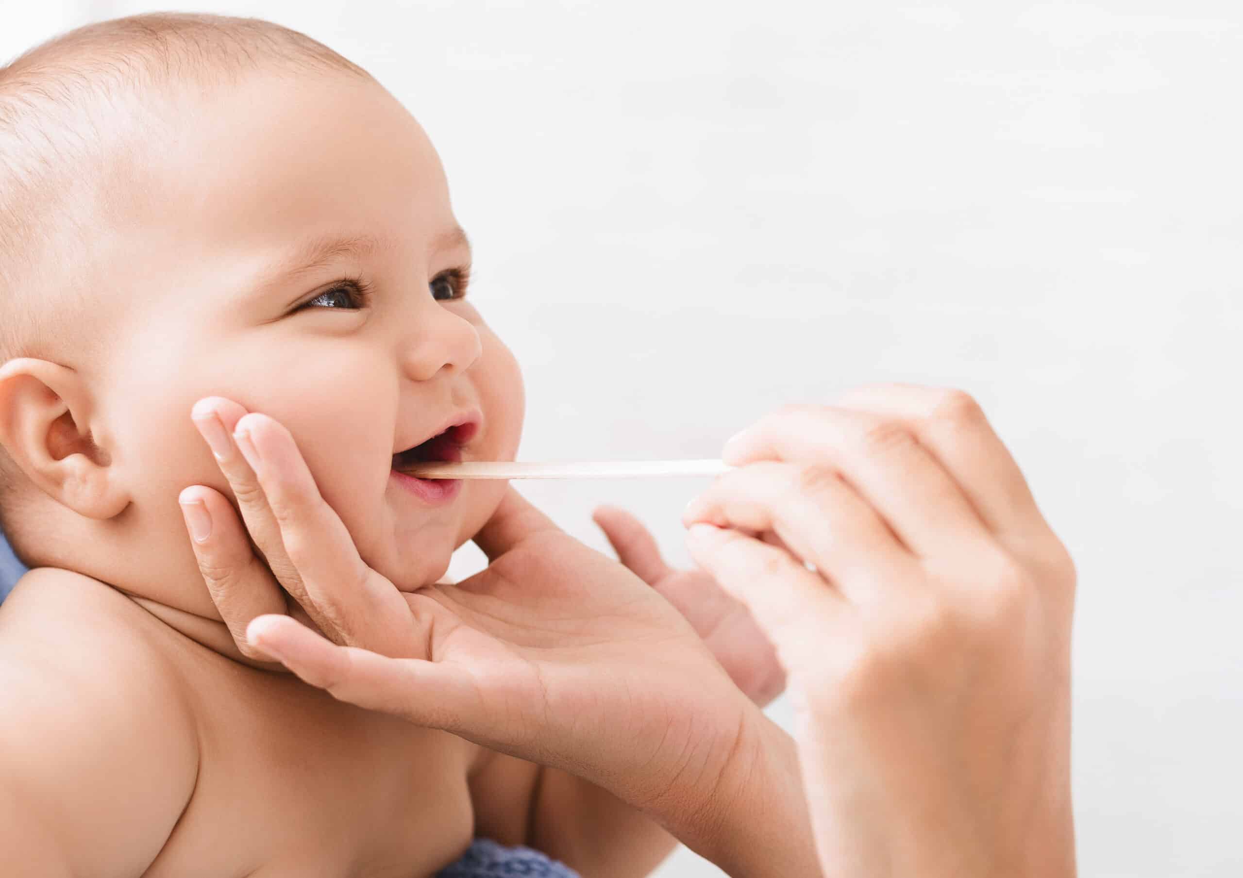 Lachendes Baby bei einer zahnärztlichen Kontrolluntersuchung